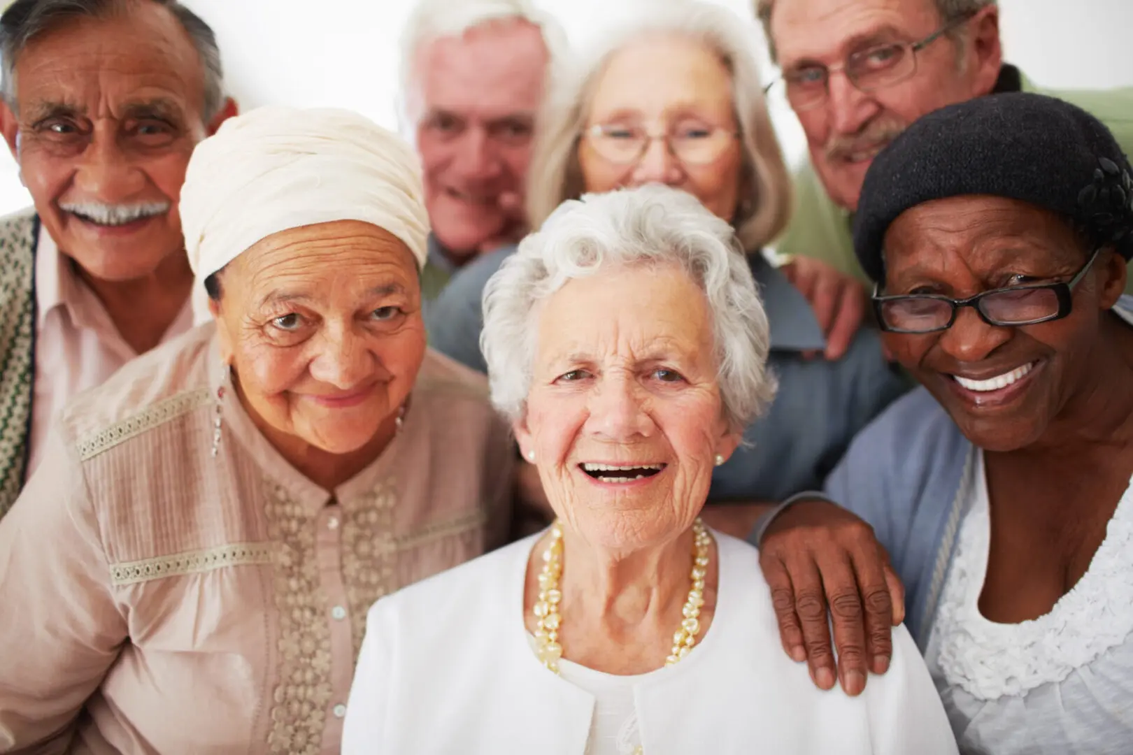 A group of seniors smiling together while in a retirement home